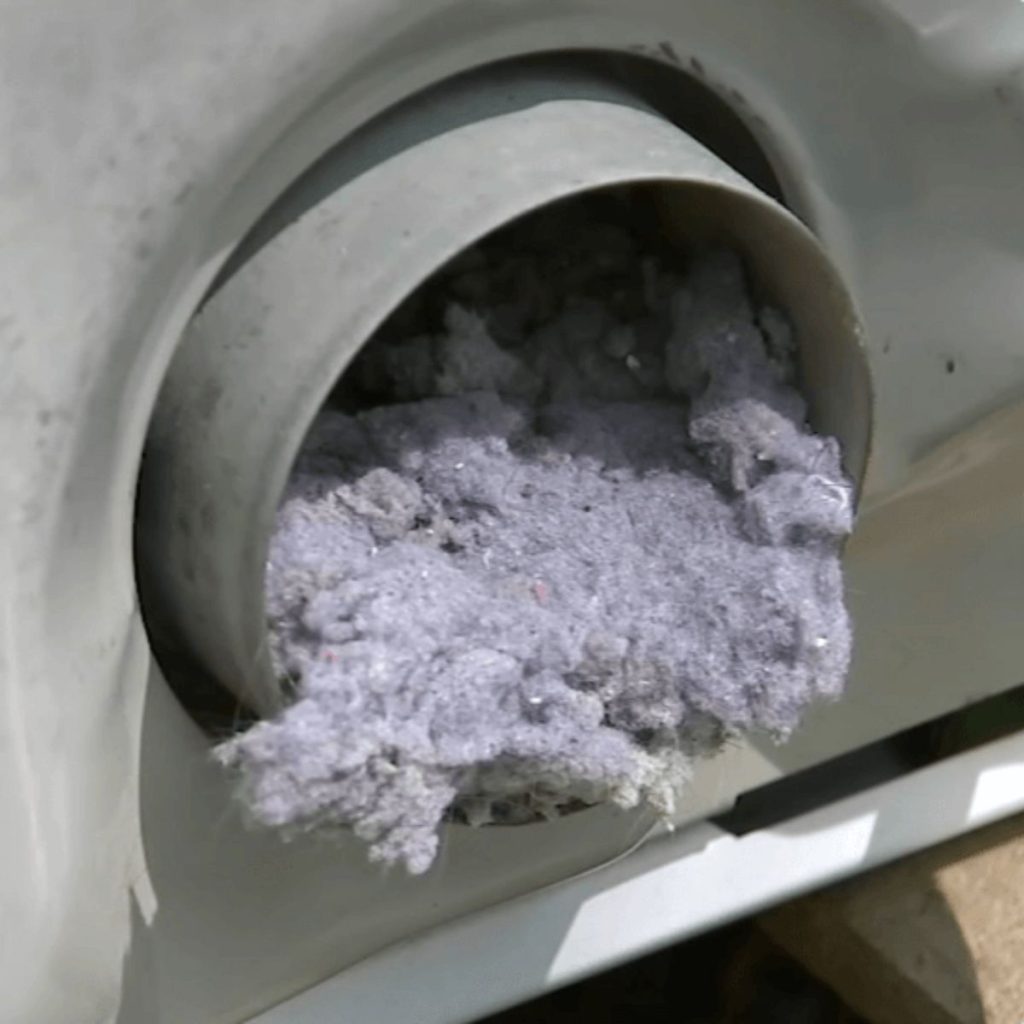 Dryer vent pipe clogged with compacted lint blocking airflow