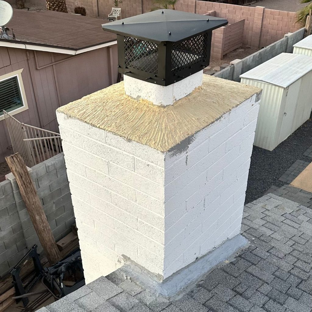 Brick chimney with new crown seal and black chimney cap installed.