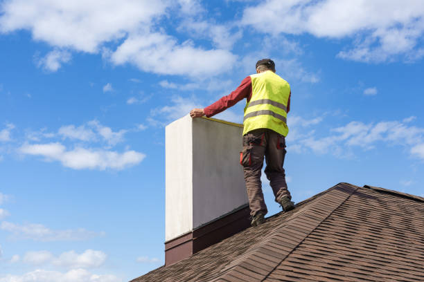 Technician inspecting a large chimney on a house roof.