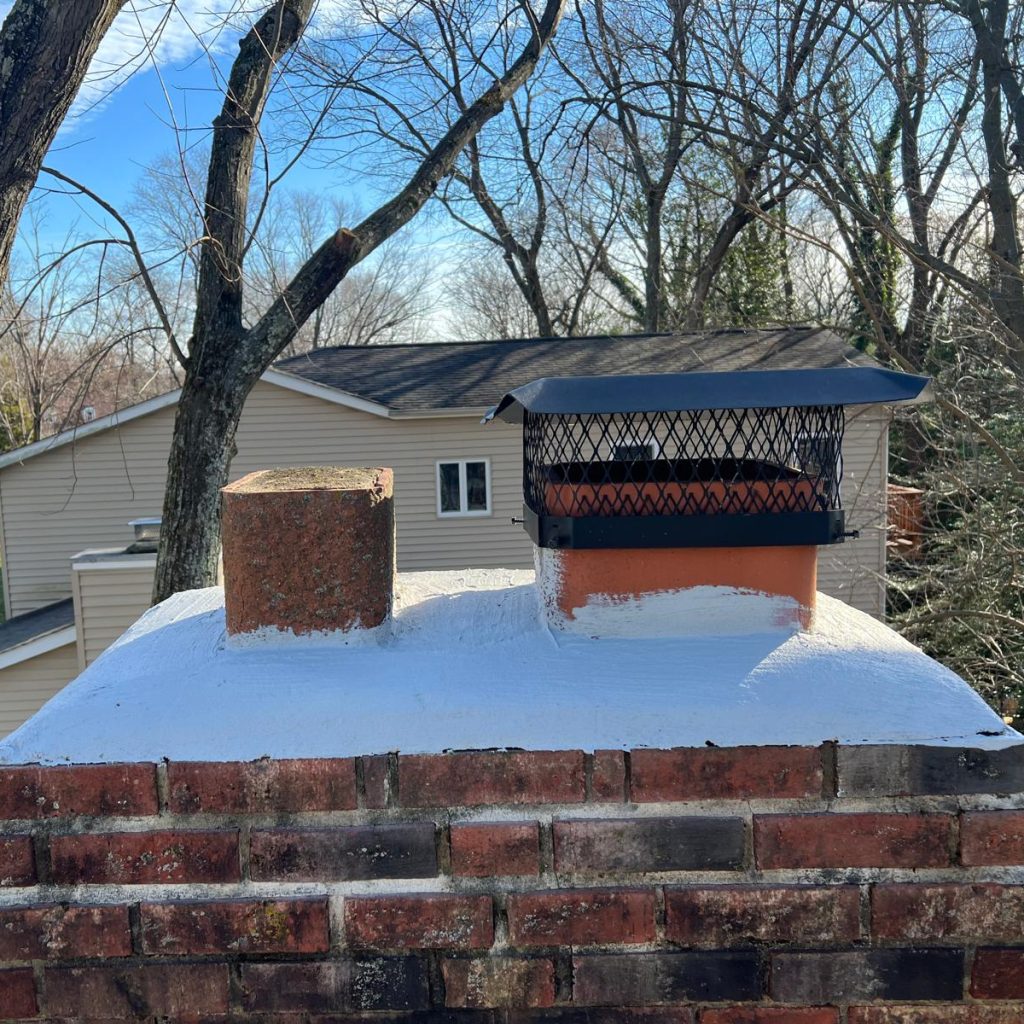 Brick chimney with fresh crown seal and new protective chimney cap.